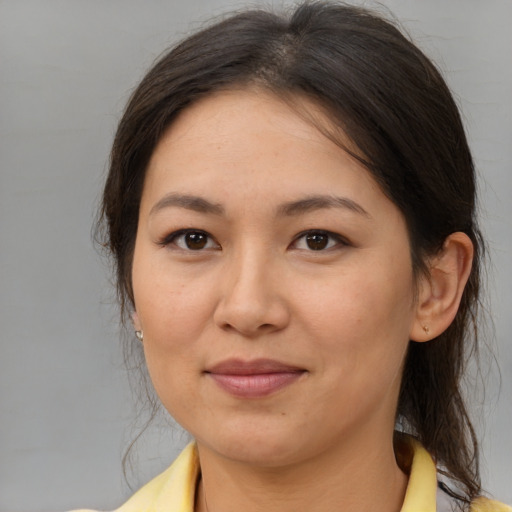 Joyful asian adult female with medium  brown hair and brown eyes