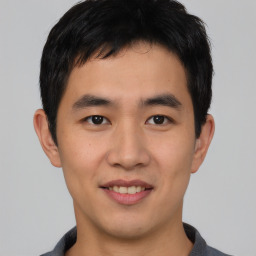 Joyful asian young-adult male with short  black hair and brown eyes