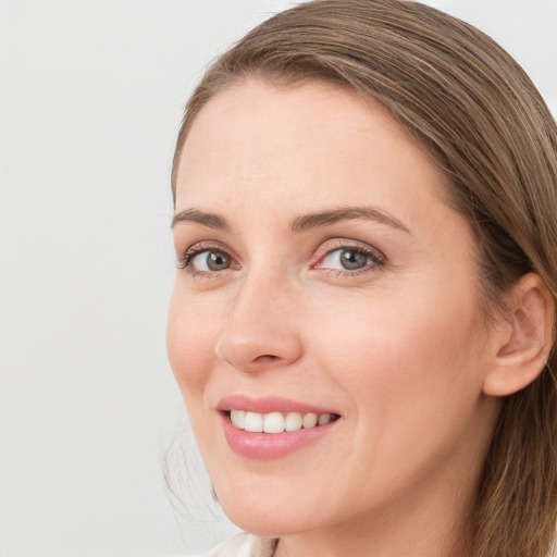 Joyful white young-adult female with long  brown hair and grey eyes