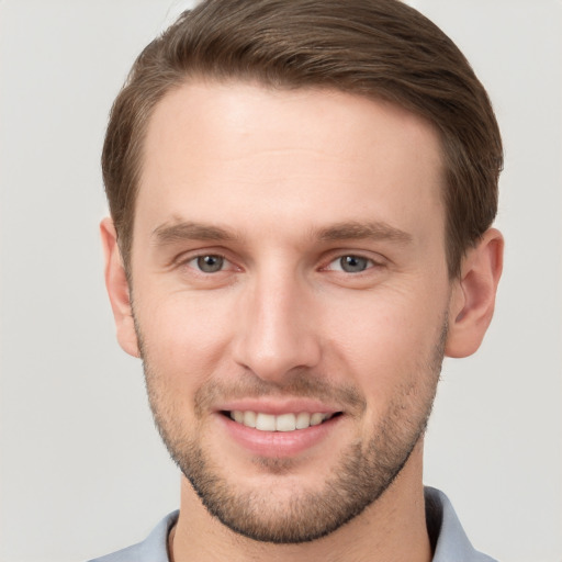 Joyful white young-adult male with short  brown hair and grey eyes