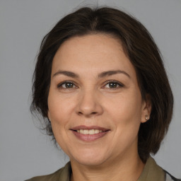 Joyful white adult female with medium  brown hair and brown eyes