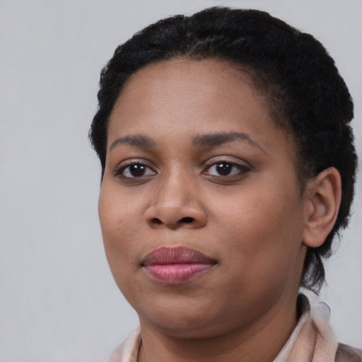 Joyful black young-adult female with short  black hair and brown eyes