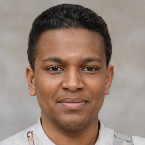 Joyful latino young-adult male with short  brown hair and brown eyes