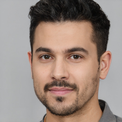 Joyful white young-adult male with short  black hair and brown eyes