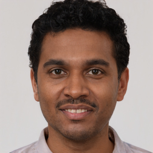 Joyful black young-adult male with short  black hair and brown eyes