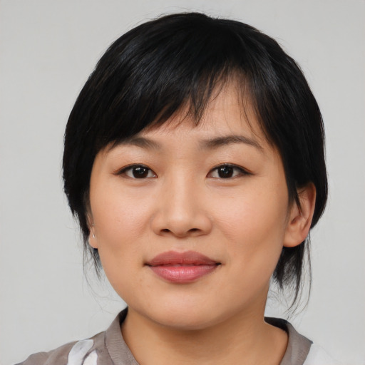 Joyful asian young-adult female with medium  black hair and brown eyes