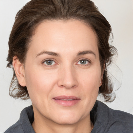 Joyful white adult female with medium  brown hair and grey eyes