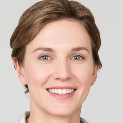 Joyful white young-adult female with short  brown hair and grey eyes