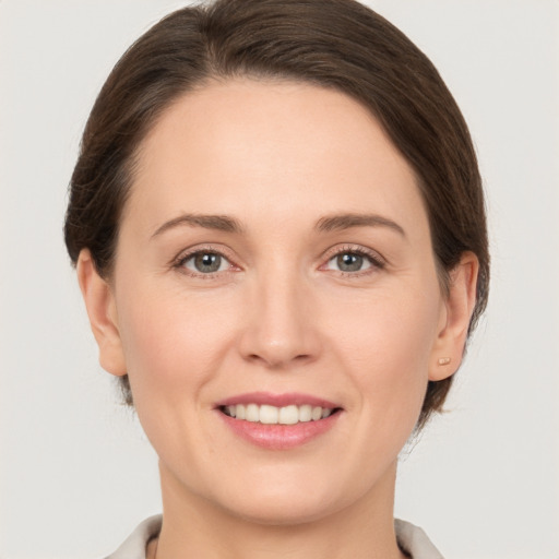 Joyful white young-adult female with medium  brown hair and grey eyes