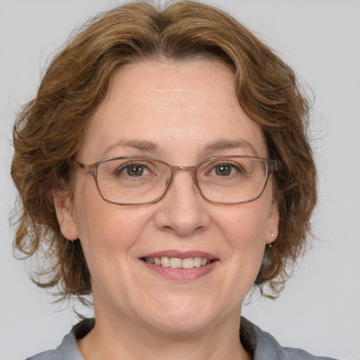 Joyful white middle-aged female with medium  brown hair and blue eyes