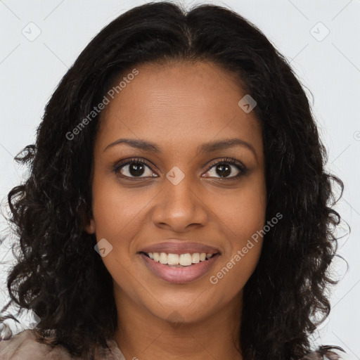 Joyful black young-adult female with long  brown hair and brown eyes