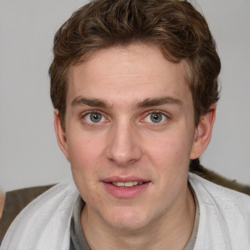 Joyful white young-adult male with short  brown hair and blue eyes