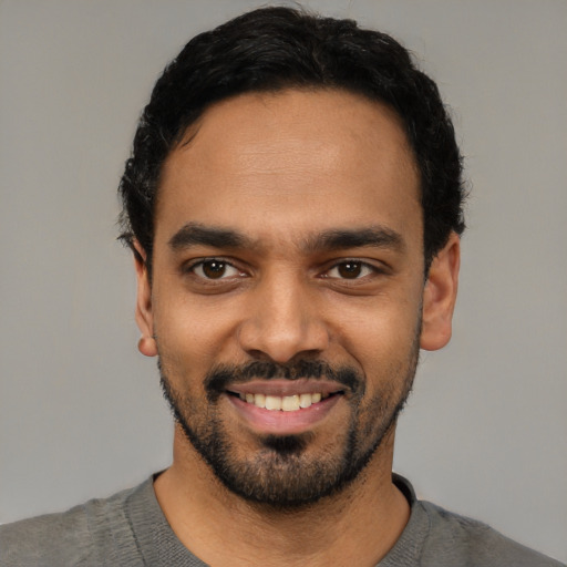 Joyful latino young-adult male with short  black hair and brown eyes