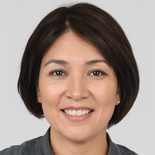 Joyful white adult female with medium  brown hair and brown eyes