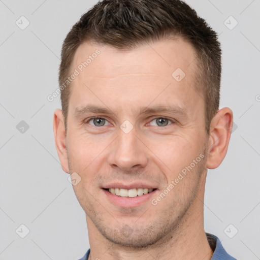 Joyful white young-adult male with short  brown hair and grey eyes