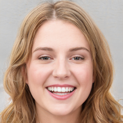 Joyful white young-adult female with long  brown hair and green eyes