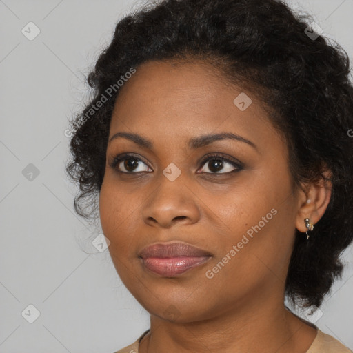 Joyful black young-adult female with long  brown hair and brown eyes