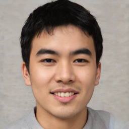 Joyful asian young-adult male with short  black hair and brown eyes