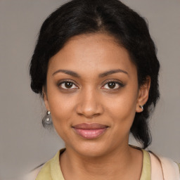 Joyful black young-adult female with medium  brown hair and brown eyes