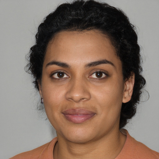 Joyful black young-adult female with medium  black hair and brown eyes