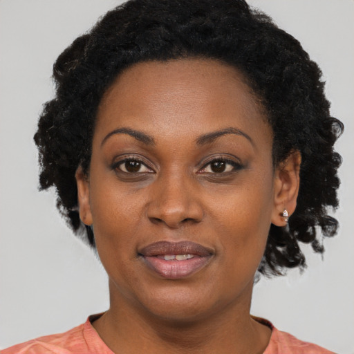Joyful black adult female with short  black hair and brown eyes