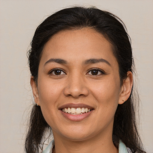 Joyful latino young-adult female with medium  brown hair and brown eyes