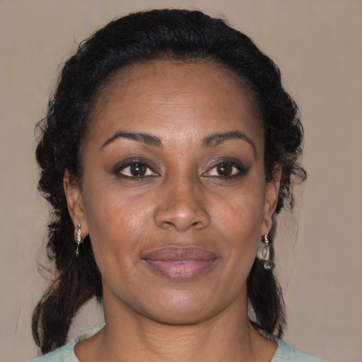 Joyful black adult female with medium  brown hair and brown eyes