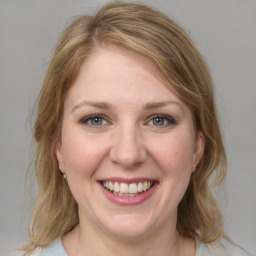 Joyful white young-adult female with medium  brown hair and blue eyes