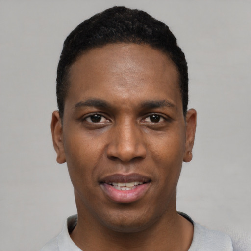 Joyful black young-adult male with short  black hair and brown eyes