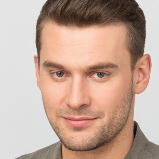 Joyful white young-adult male with short  brown hair and brown eyes