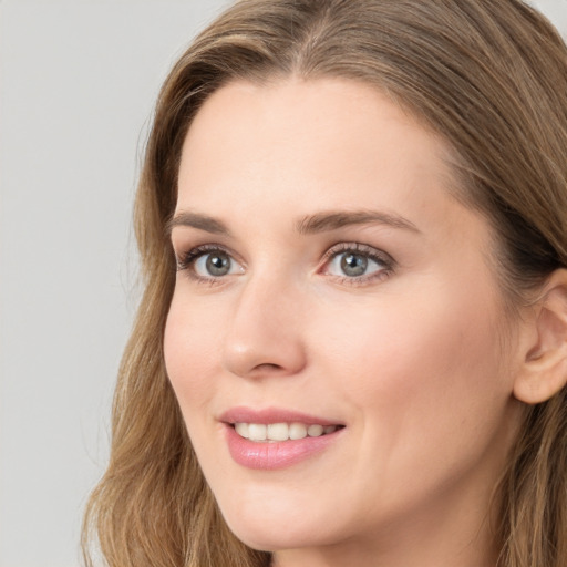 Joyful white young-adult female with long  brown hair and blue eyes