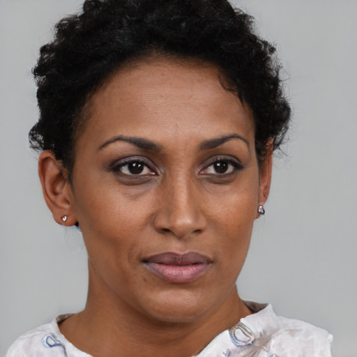 Joyful black adult female with short  brown hair and brown eyes