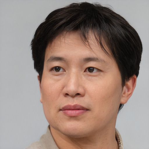 Joyful asian adult male with short  brown hair and brown eyes