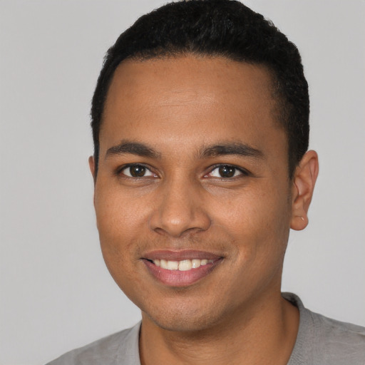 Joyful black young-adult male with short  black hair and brown eyes