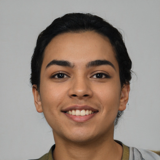 Joyful latino young-adult female with short  black hair and brown eyes