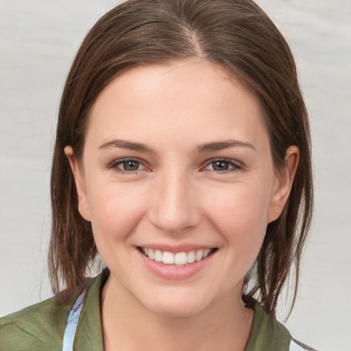 Joyful white young-adult female with medium  brown hair and grey eyes