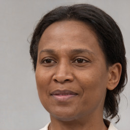 Joyful black adult female with medium  brown hair and brown eyes