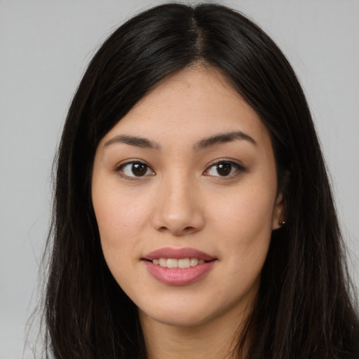 Joyful asian young-adult female with long  brown hair and brown eyes