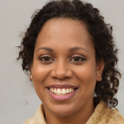 Joyful black adult female with medium  brown hair and brown eyes