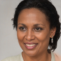 Joyful black adult female with long  brown hair and brown eyes