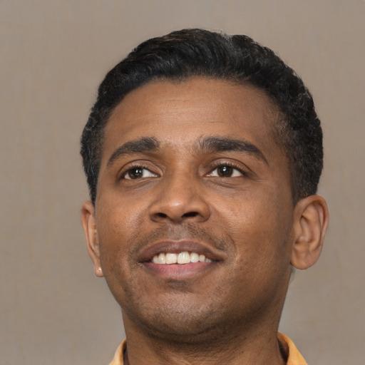 Joyful black young-adult male with short  black hair and brown eyes