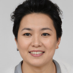 Joyful asian young-adult female with short  brown hair and brown eyes