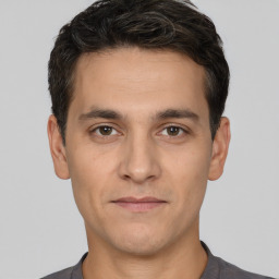 Joyful white young-adult male with short  black hair and brown eyes