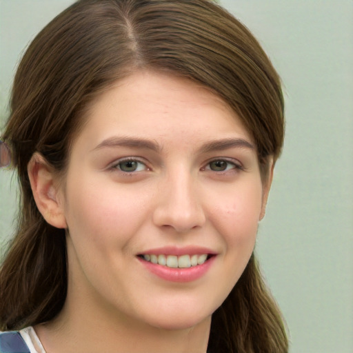 Joyful white young-adult female with long  brown hair and green eyes