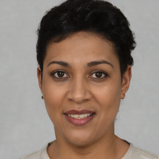 Joyful latino young-adult female with short  black hair and brown eyes