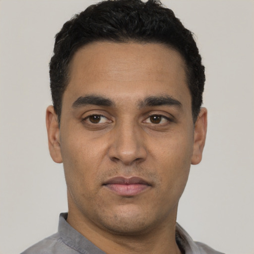 Joyful latino young-adult male with short  black hair and brown eyes