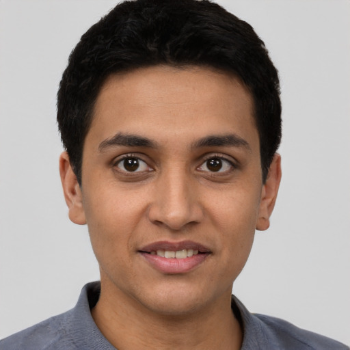 Joyful latino young-adult male with short  black hair and brown eyes