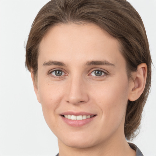 Joyful white young-adult female with medium  brown hair and grey eyes