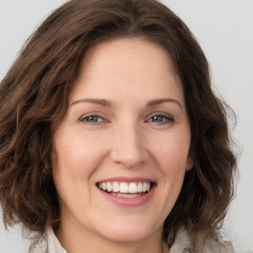 Joyful white young-adult female with medium  brown hair and green eyes