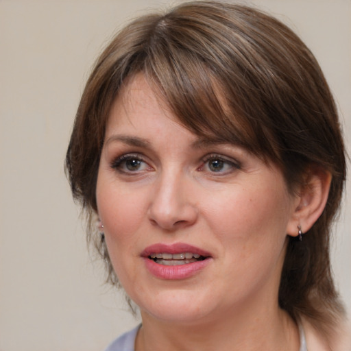 Joyful white adult female with medium  brown hair and blue eyes